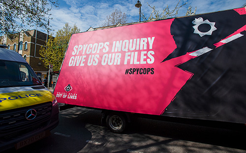 To coincide with the start of the very first <a href='https://www.ucpi.org.uk/hearings/' target='blank' rel="noopener noreferrer">Undercover Policing Inquiry</a> hearings, five years after the Inquiry began, PSOOL hire an ‘Advan’ – a 20 foot long advertising board, driven to London venues significant to the activists who were targeted by Spycops. The artwork, by Art Against Blacklisting Collective, is a beautiful backdrop to demonstrators at the hearing venue – the Amba Hotel.